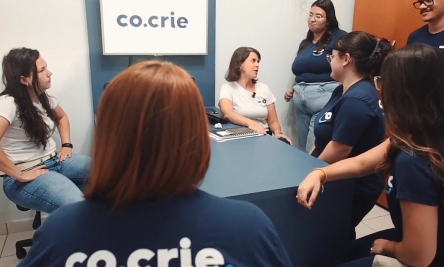 Equipe da Co.Crie reunida no escritório, em 2023
